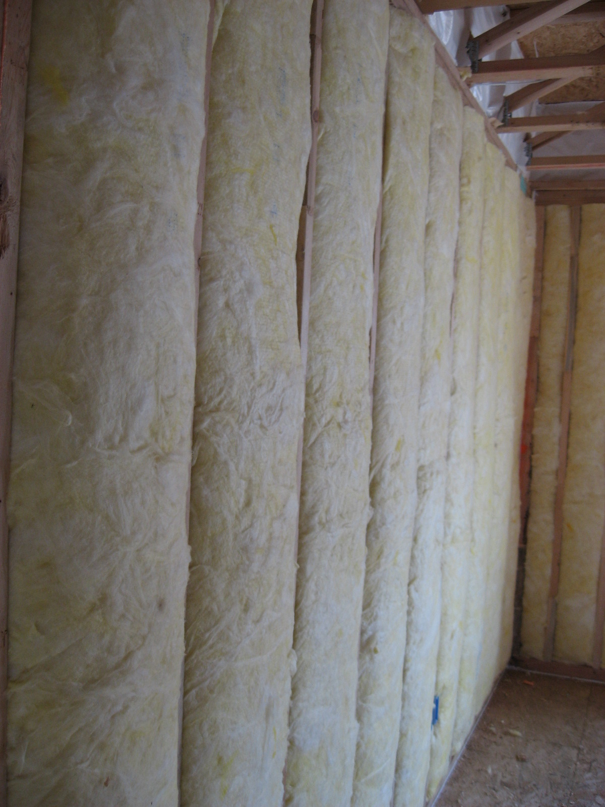 Unfaced fiberglass batt insulation is installed to completely fill the wall cavities.