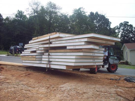 An all-terrain forklift is used to move and stage the panels.