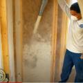 Right – Fiberglass insulation is blown in to fill wall cavities. 