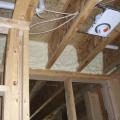 Right – Closed-cell spray foam insulates and air-seals the rim joist above a shared wall between the garage and living space.