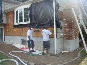 Siding has been removed so cellulose insulation can be dense-packed into the exterior walls of this home